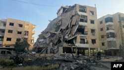 Residents gather at the site of an overnight Israeli air strike that targeted a neighborhood in the southern coastal city of Tyre on March 13.