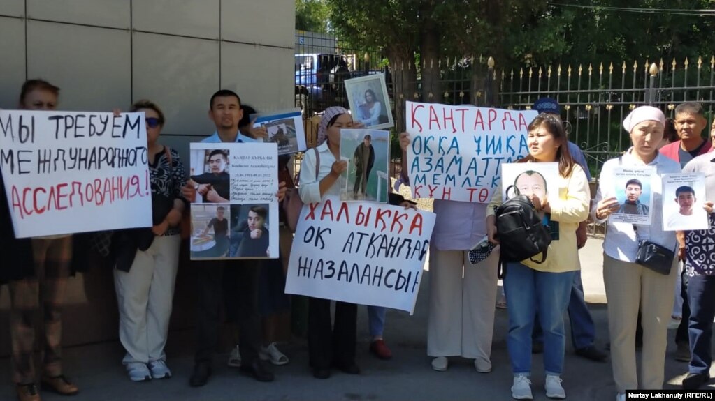 Участники акции протеста держат плакаты перед зданием прокуратуры. Алматы, 1 июня 2022 года