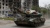 Pro-Russia troops drive a tank along a street in the town of Popasna in Ukraine's Luhansk region.