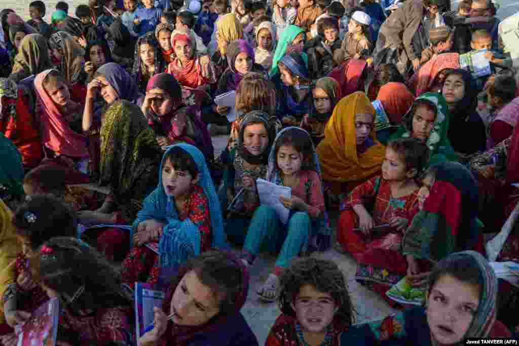 Afghan children attend a class at a mobile school in Kandahar, which is an initiative by volunteers wherein a vehicle carrying study materials travels from village to village conducting classes for.