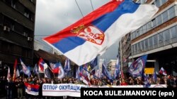 Protesters wave a large Serbian flag during a demonstration against NATO in Belgrade in March 2016. 