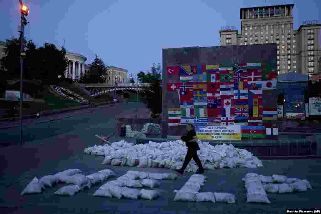 A man walks by sand bags forming the word &quot;Help&quot; at Independence Square, the Maidan, in Kyiv on June 6.