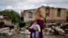 Nila Zelinska plače dok stoji ispred svoje porušene kuće u selu Potašnja, u blizini Kijeva i u rukama drži lutku koja je pripadala njenoj unuki, 31. maja 2022.