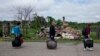 Natalia Didenko,&nbsp;Eduard Zelenskiy, and his wife, Nila Zelinska, walk by destroyed houses on the way to their home in the village of Potashnya, near Kyiv, on May 31.<br />
<br />
When Russia invaded Ukraine on February 24, it triggered one of the largest humanitarian crises in Europe&#39;s recent history, with an estimated 12.8 million people displaced, most of whom have not left the country.