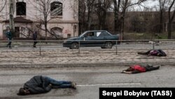 افراد ملکی در روی یکی از جاده های اوکراین که توسط قوای روسی هدف قرار گرفته و کشته شده اند