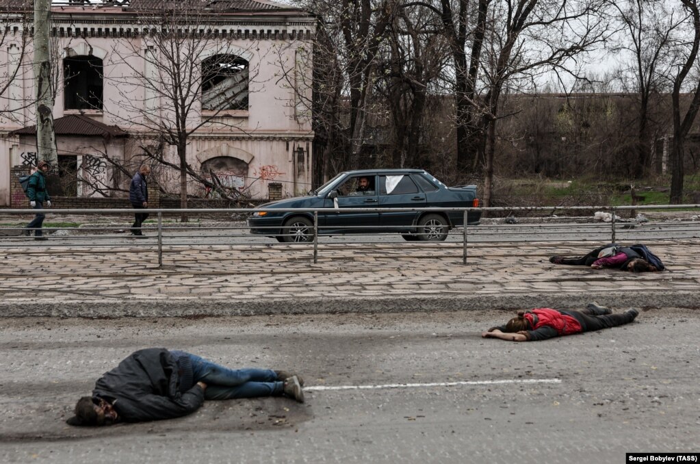 Trupat e pajetë të njerëzve të veshur me rroba civile në një rrugë në Mariupol më 16 prill.