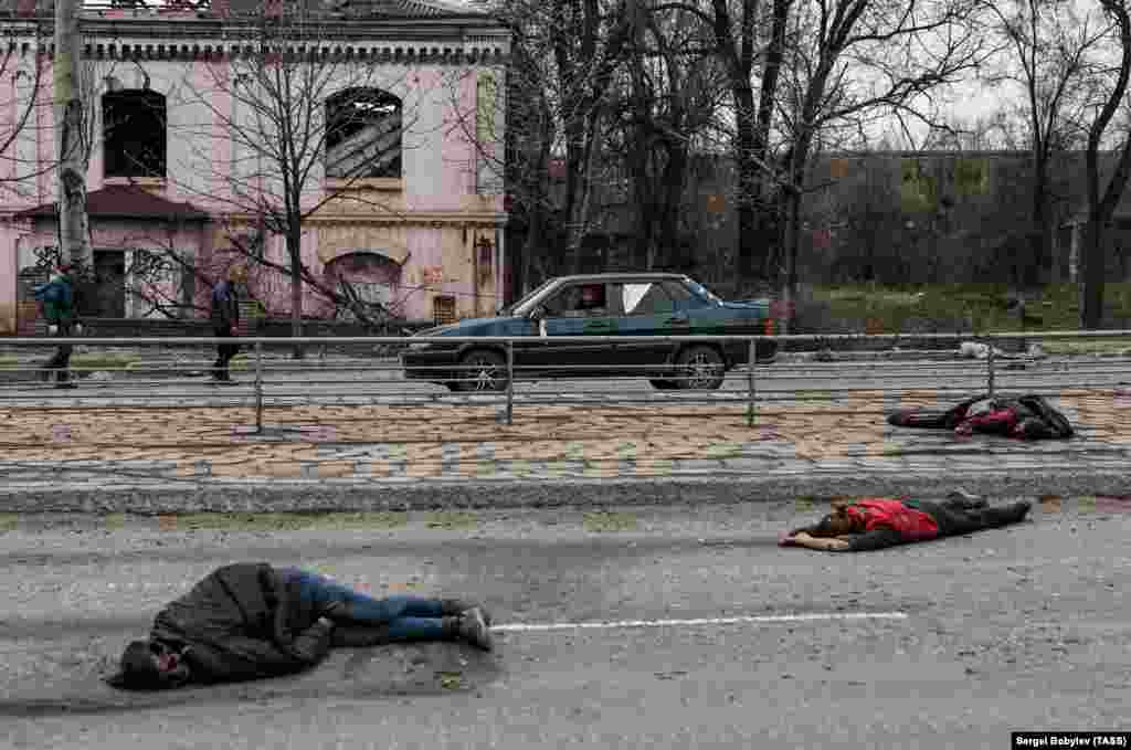 The bodies of people dressed in civilian clothing lie on a road in Mariupol on April 16.&nbsp;