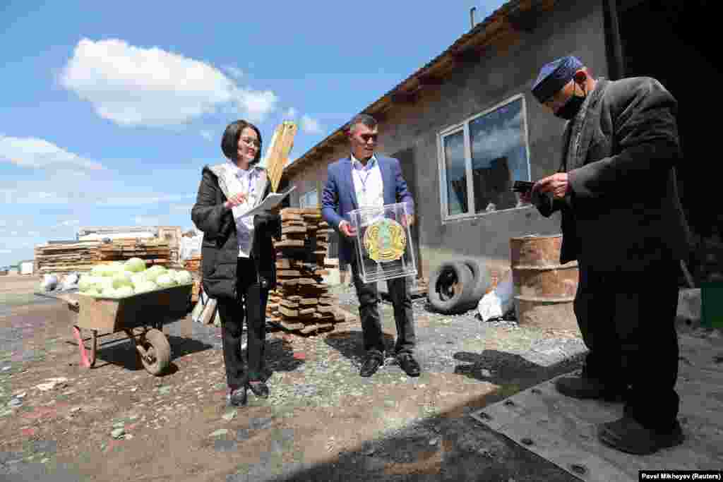 A man carries a ballot box to the homes of local residents who cannot come to the polling station during a constitutional referendum in Koyandy, in Kazakhstan&#39;s Aqmola region on June 5.