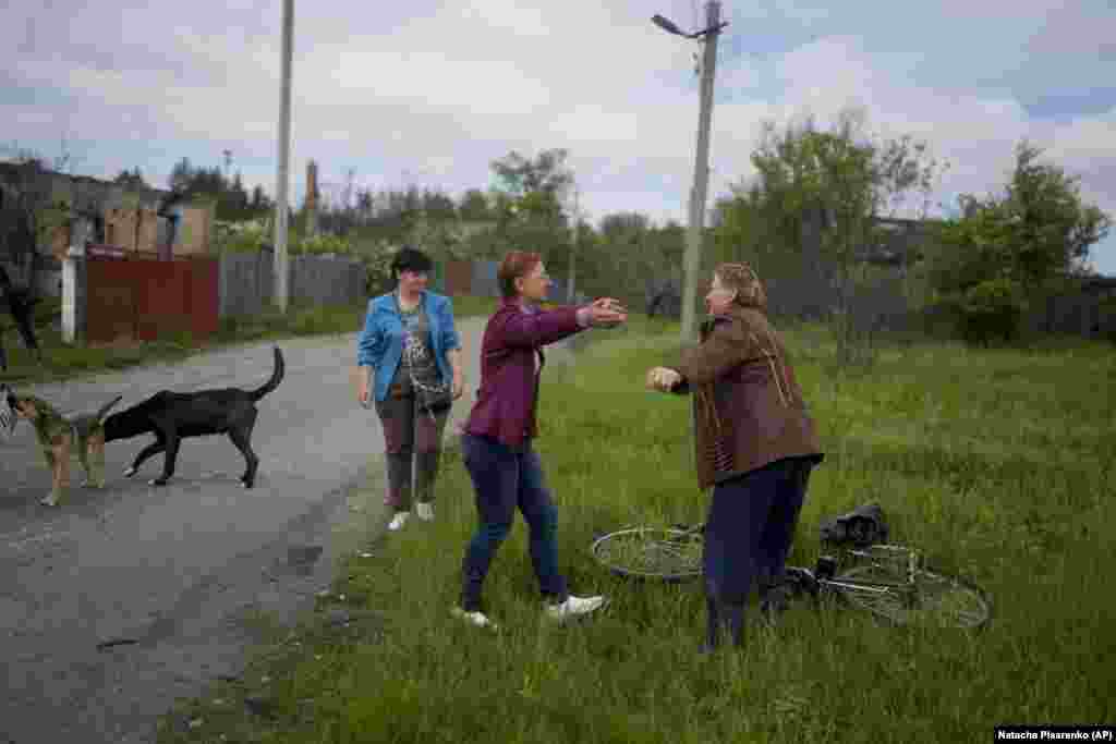 Nila Zelinska (center) greets a neighbor after arriving home in Potashnya.