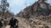 A man crouches amid the rubble in the Livoberezhnyi district of Russian-controlled Mariupol on June 6. 