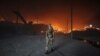 A Ukrainian soldier walks passes a burning grain silo that was shelled repeatedly amid Russia's invasion of Ukraine, in Donetsk region on May 31.
