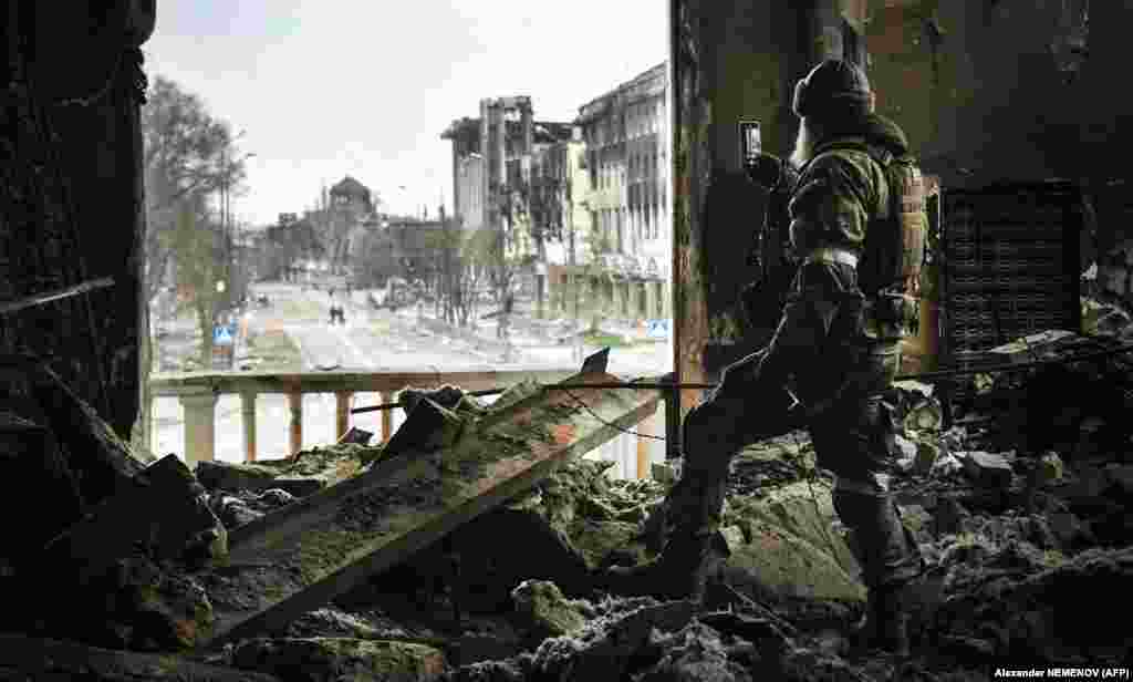 A Russian soldier takes a photo down the main street of Mariupol from the city&#39;s destroyed performing arts theater on April 12. &nbsp;
