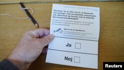 A person holds a ballot reading Ja = Yes and Nej = No, as Danes vote in a referendum on the European Union defense opt-out on June 1.