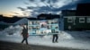 Men in the Greenlandic capital, Nuuk, carry a large poster for the Democrats party, which topped the polls in parliamentary elections on March 11. 