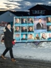 Men in the Greenlandic capital, Nuuk, carry a large poster for the Democrats party, which topped the polls in parliamentary elections on March 11. 