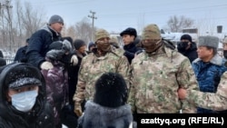  Аким Западно-Казахстанской области Гали Искалиев (в центре, за солдатами) появился на митинге в окружении спецназа. Уральск, 4 января 2022 года

