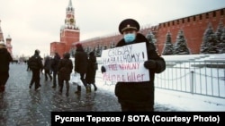 Oleg Kashintsev, a former Russian policeman, holds a placard reading "Free Navalny! Putin is a killer!" on Moscow's Red Square in 2021.