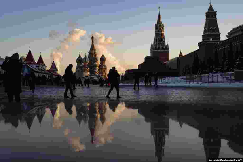 Mai multe persoane se plimbă în Piața de Crăciun amenajată în Piața Roșie din Moscova, Rusia.