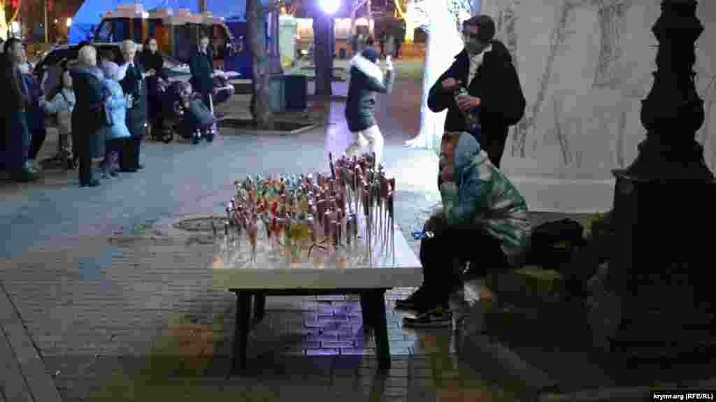 У входа на Приморский бульвар ребята продают петушков на палочке