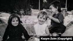 Три от децата, изселени от България. Седнали са върху чувалите с вещи, пренесени от възрастните през лятото на 1989 г.