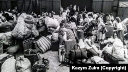 Над 300 хил. български турци са изселени в Турция през лятото на 1989 г. Тази снимка на Казъм Заим показва пристигането на част от тях в Турция. Повечето снимки от това време документират напускането на България с автомобил. Тази илюстрира пътуването с влак, наричан в Турция "влак на срама".