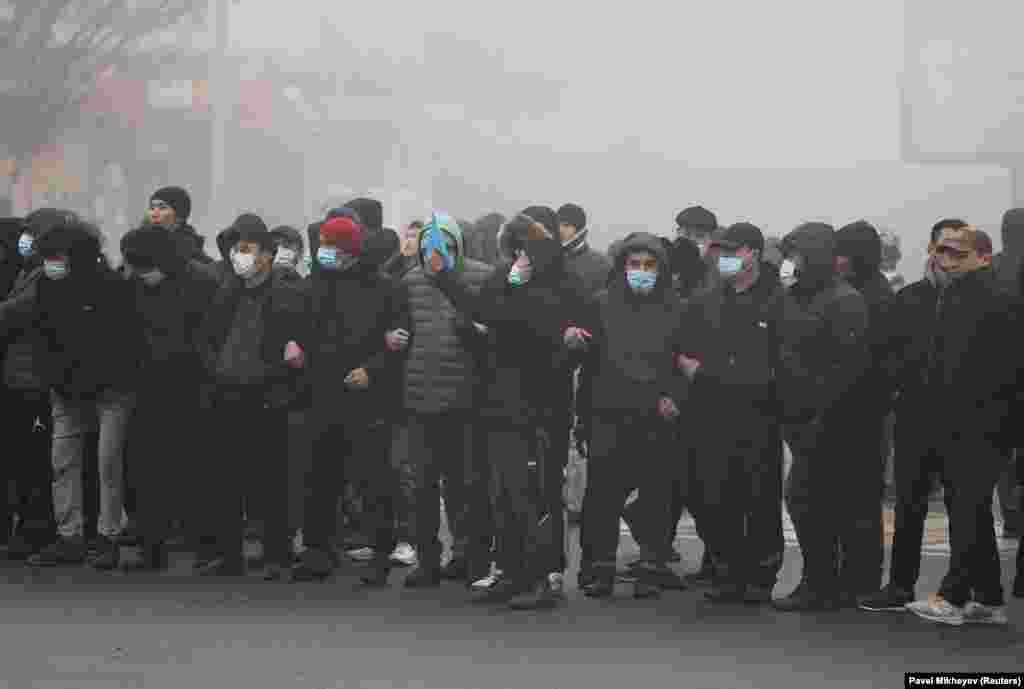 Demonstrators link arms in Almaty on January 5.&nbsp;
