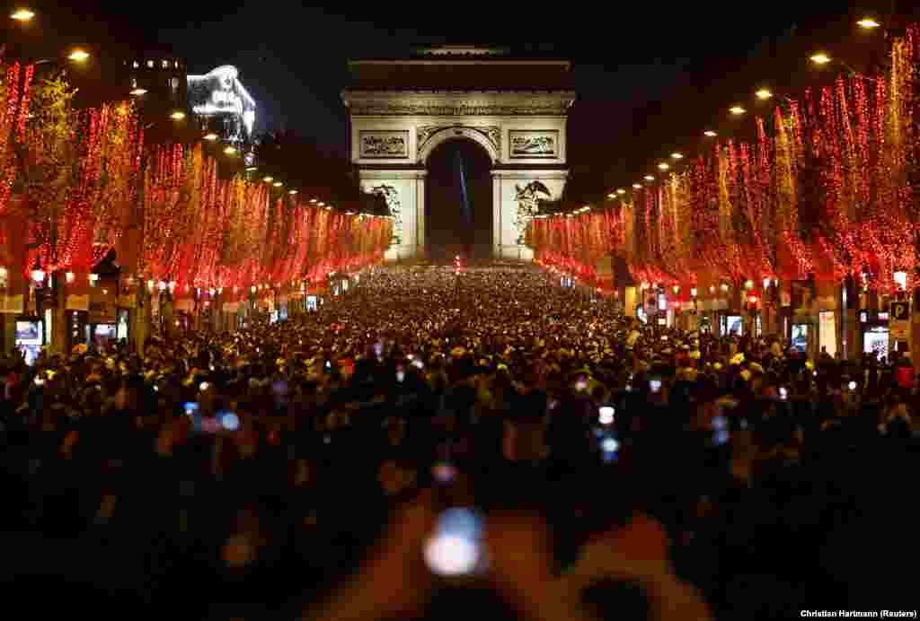 Qytetarët marrin pjesë në festimet për Vitin e Ri në&nbsp;Champs-Elysees të Parisit. Këtë vit, autoritetet anuluan festimet tradicionale me fishekzjarrë dhe drita për shkak të pandemisë së koronavirusit. Paris, 31 dhjetor 2021.&nbsp; &nbsp;