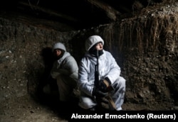Az önkényesen kikiáltott Luhanszki Népköztársaság fegyveresei egy lövészárokban, a demarkációs vonal közelében található Frunze településnél 2021. december 24-én