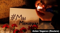 Supporters light candles in St. Petersburg in December after Russia's Supreme Court ruled that Memorial International must be liquidated for breaking the onerous "foreign agent" law. This card shows a hashtag saying: "We Are Memorial."