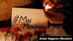 Támogatók gyertyákat és virágokat helyeznek el a szentpétervári Szoloveckij-kőnél, miután az orosz legfelsőbb bíróság december 28-án úgy döntött, hogy a Memorialt fel kell számolni a külföldiügynök-törvény megsértése miatt