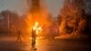 Protestuesit djegin një veturë pranë zyrës së kryetarit të qytetit të Almatit më 5 janar 2022.
