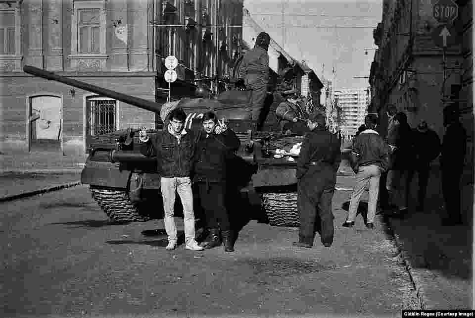 Cătălin Regea, &#238;n st&#226;nga fotografiei, cu pantaloni deschiși la culoare, &#238;n fața unui tanc din Tmișoara. Decembrie 1989