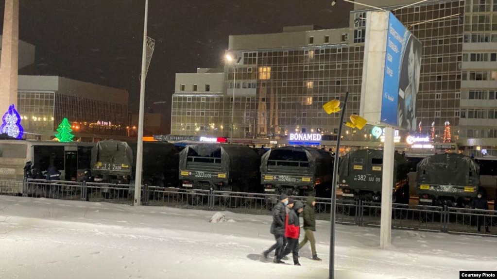 Полицейские и грузовики Нацгвардии МВД на улице в Караганде, где стоят митингующие. 4 января 2022 года