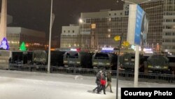 Полицейские и грузовики Нацгвардии МВД на улице в Караганде, где стоят митингующие. 4 января 2022 года