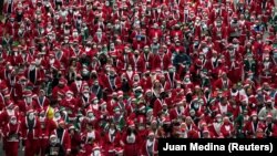 Люди в костюмах Санта-Клауса беруть участь у благодійному забігу зі збору коштів на допомогу постраждалим від виверження вулкану Кумбре-В’єха в Мадриді, Іспанія, 19 грудня 2021 року.