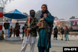 Taliban fighters guard a protest where demonstrators demanded the unfreezing of central banks assets abroad to alleviate the humanitarian crisis, in Kabul on January 2.