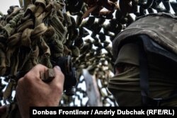 Український військовий спостерігає за активністю противника у полях неподалік селища Старогнатівка, 24 липня 2021 року