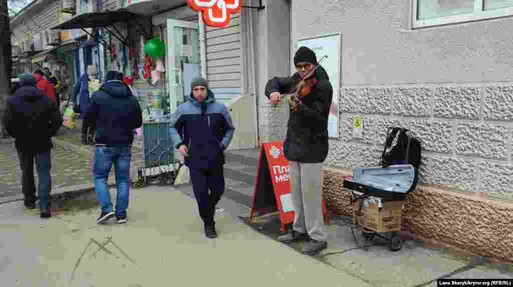 Уличный скрипач создает праздничное настроение прохожим