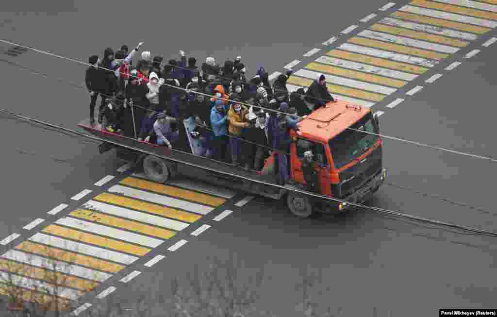 Demonstrators ride a truck in Almaty on January 5. One of the men is carrying a stick, another holds what appears to be a riot policeman&#39;s shield.&nbsp;