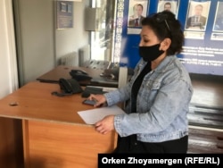 Активистка Айткуль Кашырбекова в полицейском отделении выясняет размер наложенного на нее штрафа, 30 апреля 2021 года.