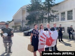 Pred početak sednice, iz pokrajinske skupštine je izašlo nekoliko opozicionih poslanika koji su razvili transparent sa crvenom šakom.