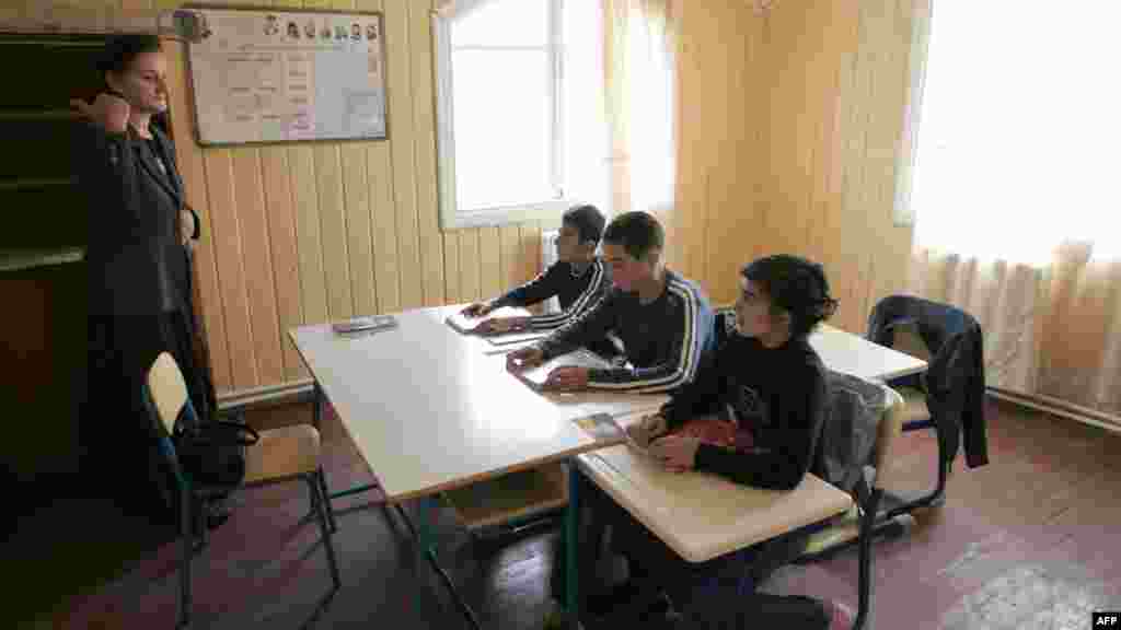 A Georgian teacher gives a lesson for three schoolboys in the South Ossetian village of Akhmaji.