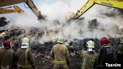 Rescue teams clear debris at the site of a high-rise building, which collapsed in Terhan on january 19.