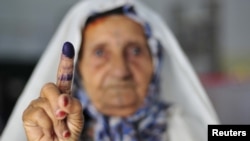 Libya -- A woman shows her ink-stained finger after casting her vote during the National Assembly election in Benghazi, 07Jul2012