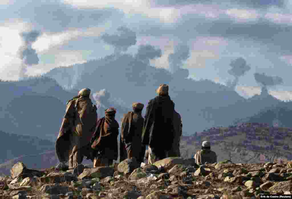 Afghan fighters watch explosions from U.S. bombs rock Afghanistan&rsquo;s Tora Bora mountain complex in December 2001. &nbsp; When the United States invaded Afghanistan in the wake of the September 11 attacks, a massive aerial assault backed by ground fighters was launched on a series of mountain caves known as Tora Bora. Bin Laden and his Al-Qaeda fighters were believed to be hiding inside Tora Bora in those mountains before he escaped to Pakistan.