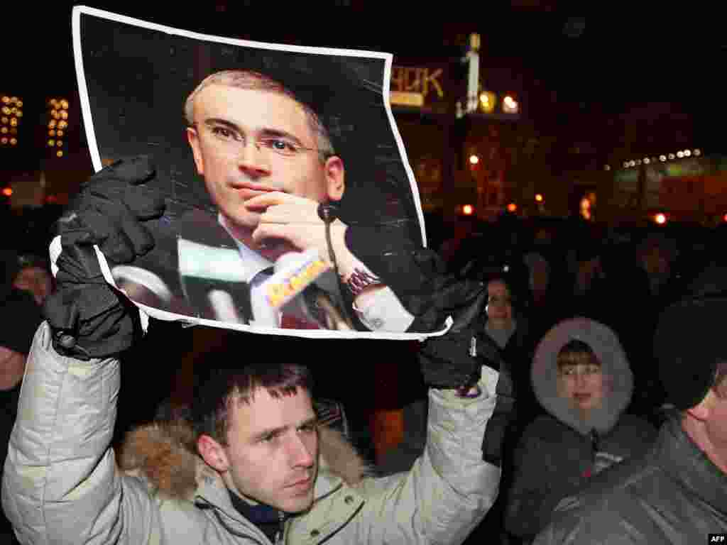 A demonstrator holds a portrait of jailed ex-tycoon Mikhail Khodorkovsky at Triumph Square.
