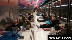 Oamenii se adăpostesc într-o stație de tren în timpul unui atac cu rachete din Iran asupra Tel Avivului, Israel, pe 1 martie 2026. 