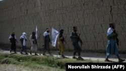 FILE: Afghan Taliban militants walk in the outskirts of the eastern city of Jalalabad.