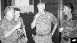 General Ratko Mladić (levo) nazdravlja sa holandskim komandanta UN snaga Tomom Karremansom (drugi s desna), ostali prisutni su nepoznati, Potočari, 12. jul 1995.