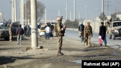 Сотрудник сил безопасности Афганистана у места взрыва. Кабул, 18 ноября 2019 года.